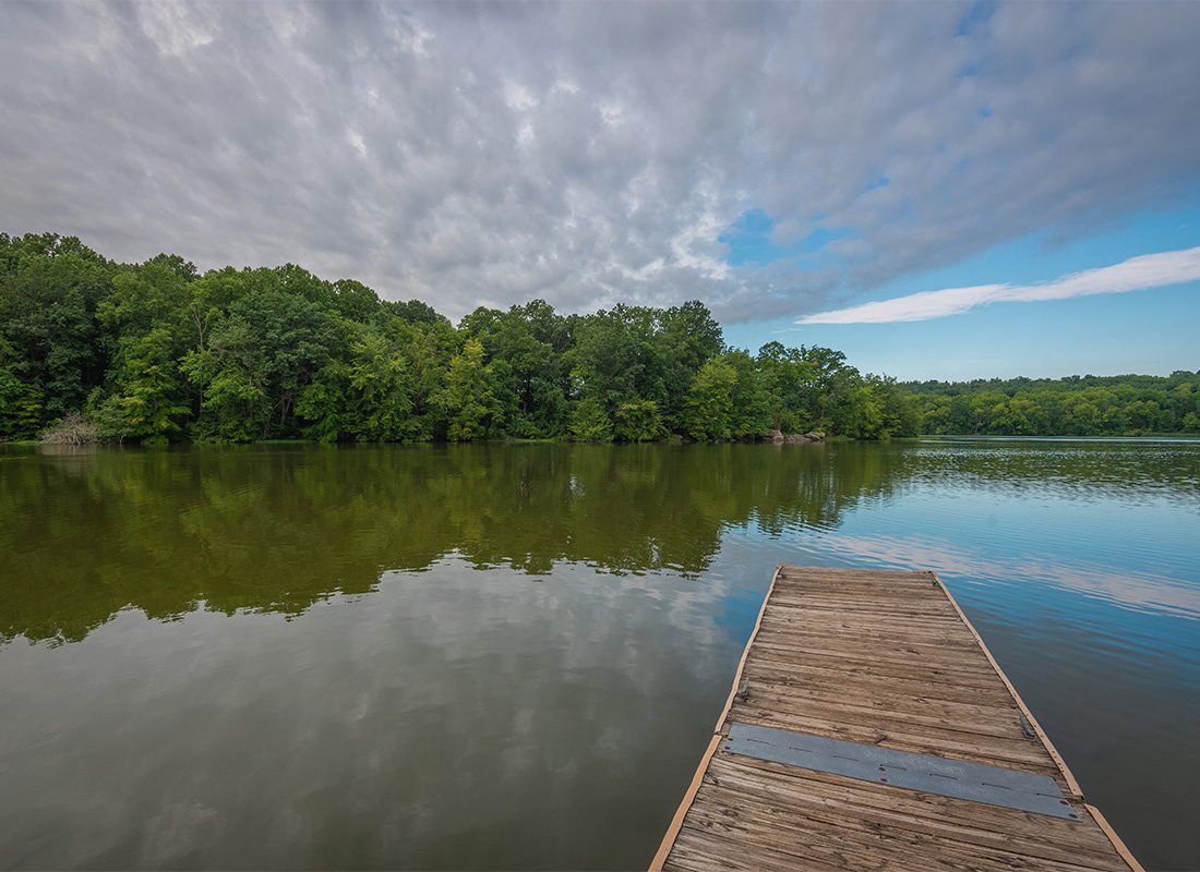 Insurance Solutions - Scenic View of a Wooden Dock on the Lake with Green Trees in the Background Against a Cloudy Sky in Pinchot Park